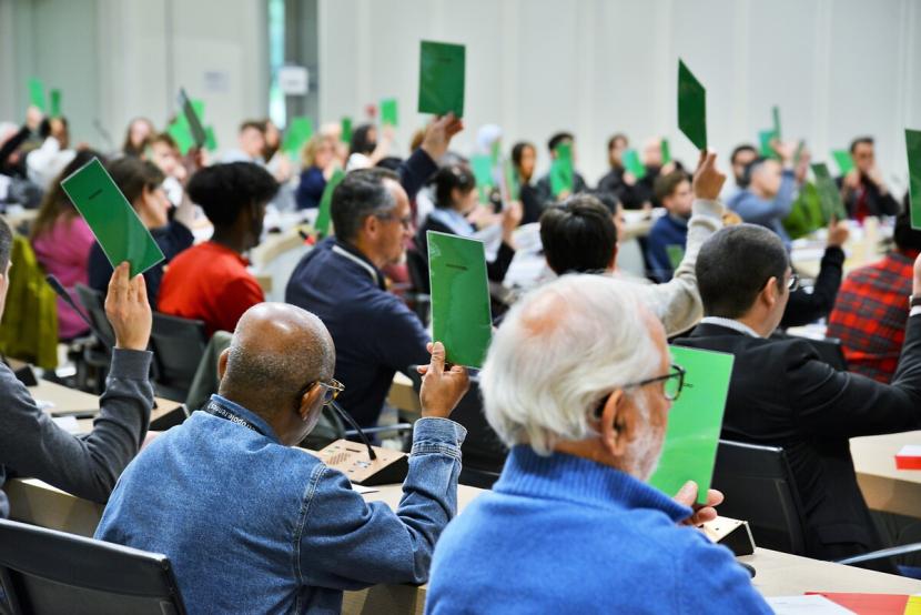 Vote de la charte de la participation citoyenne. Les votants utilisent des cartons de couleurs pour désigner leur choix.