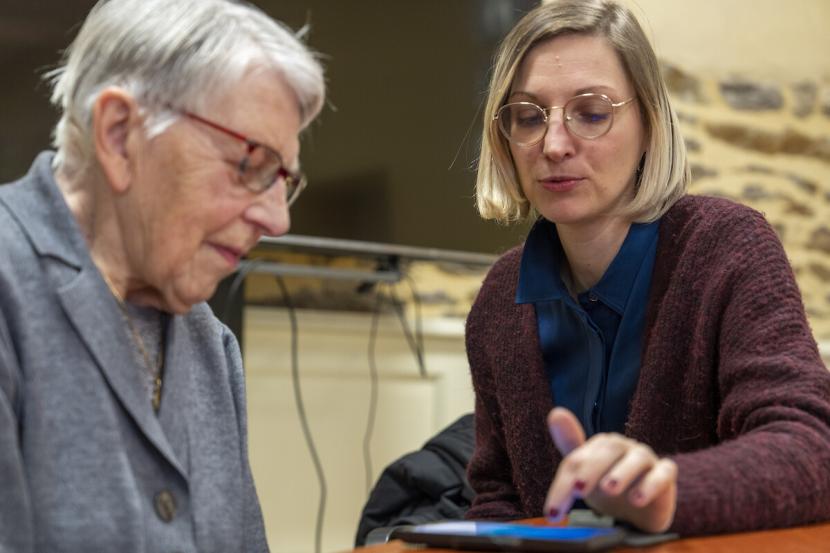 Deux femmes, une conseillère numérique et une usagère apprennent à utiliser un smartphone.