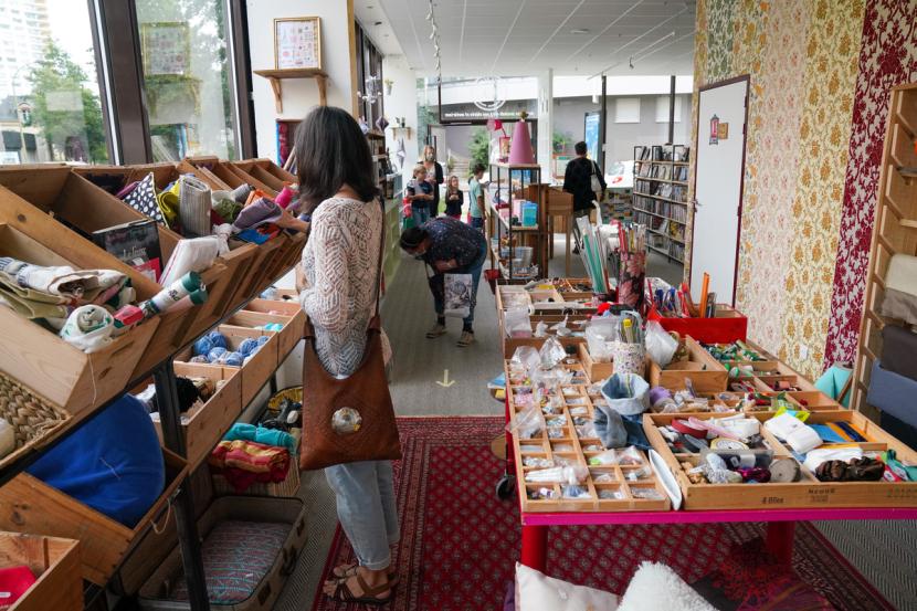 Une femme regarde des tissus dans la boutique de La Belle Déchette