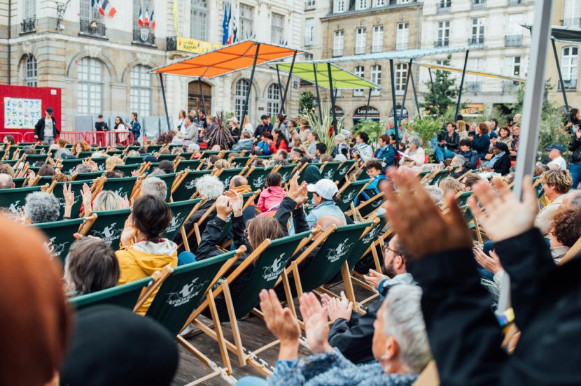 Des personnes applaudissent sur leurs transats place de la Mairie à Rennes