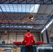 Une athlète saute sur un trampoline.