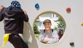 Un enfant escaladant et Thibault Siegfriedt, enseignant de la classe à l'initiative du projet.