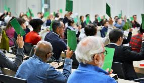 Vote de la charte de la participation citoyenne. Les votants utilisent des cartons de couleurs pour désigner leur choix.